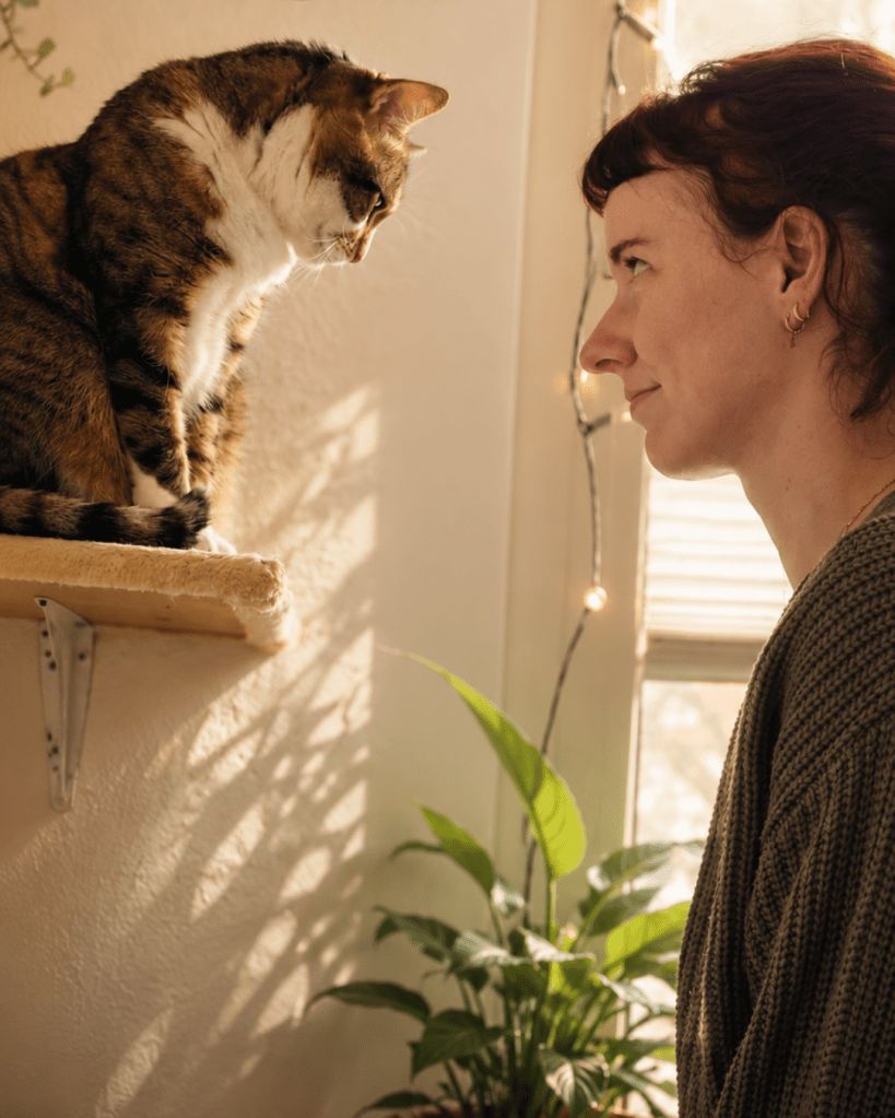 Frau und Katze sehene sich an